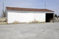 Large white painted garage with rusty roof