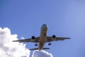 A large white passenger plane flying in a blue sky with many white and dark blue and gray clouds Royalty Free Stock Photo