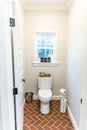 Large white renovated master bathroom toilet area with red brick floors Royalty Free Stock Photo