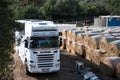 Large white Scania truck parked in a horse race in a rural area on a sunny day