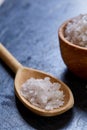 Large white sea salt in a natural wooden bowl on dark background, top view, close-up, selective focus Royalty Free Stock Photo