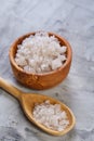 Large white sea salt in a natural wooden bowl on light background, top view, close-up, selective focus Royalty Free Stock Photo