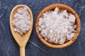 Large white sea salt in a natural wooden bowl on dark background, top view, close-up, selective focus Royalty Free Stock Photo