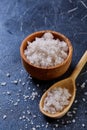 Large white sea salt in a natural wooden bowl on dark background, top view, close-up, selective focus Royalty Free Stock Photo