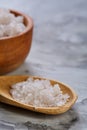 Large white sea salt in a natural wooden bowl on dark background, top view, close-up, selective focus Royalty Free Stock Photo