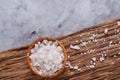 Large white sea salt in a natural wooden bowl on dark background, top view, close-up, selective focus Royalty Free Stock Photo