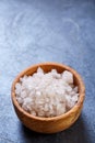 Large white sea salt in a natural wooden bowl on dark background, top view, close-up, selective focus Royalty Free Stock Photo