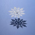 A large white snowflake and its shadow on a blue background. Minimal winter concept Royalty Free Stock Photo