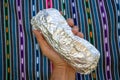 Hand Holding a Large Whole California-style Burrito Wrapped in Foil