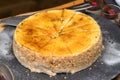 Large whole savoury cheese cake on wood plate.