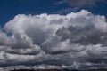 Large white and gray cumulus clouds fill the blue sky with shapes Royalty Free Stock Photo