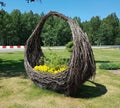 Large wicker baskets of brushwood with beautiful yellow flowers by the road