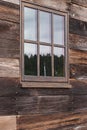 Large window on a wooden building reflecting the sky on a cloudy overcast day