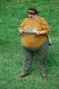 A large woman reading a pamphlet