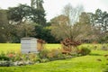 Large wooden Beehive seen located in a large garden setting.