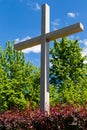 A large wooden crucifix in the city park. Place of religious worship. Catholic faith. A cross under a blue sky against a backgroun Royalty Free Stock Photo