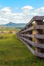 A large wooden fence on a private plot in the village of Shigaevo in the Southern Urals against the backdrop of mountains and Arvy Royalty Free Stock Photo