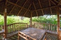 Large wooden garden house with table and benches for rest. Inside of gazebo under construction and electric sockets.