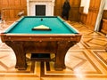 Large wooden massive expensive pool table with a green cloth for playing billiards Royalty Free Stock Photo
