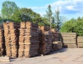 Large wooden planks stacked in racks for drying under the open sky in an industrial area. Timing of wood for carpentry. Manufactur Royalty Free Stock Photo