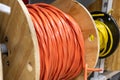 Large wooden spools - tightly wound orange and yellow cables - industrial setting - electrical wiring Royalty Free Stock Photo