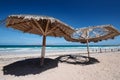 Large wooden umbrellas at sandy tropical beach