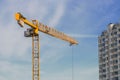 Large yellow construction crane, multi-storey house against the Royalty Free Stock Photo