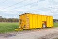 Large yellow manure tank standing in meadow Royalty Free Stock Photo