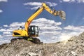 A large yellow crawler excavator moving stone or soil in a quarry. Heavy construction hydraulic equipment. excavation. Rental of