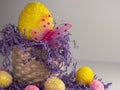 Large yellow Easter egg with a pink butterfly in a whicker basket with purple paper shreds spilling out and several yellow and