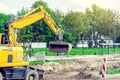 Large yellow excavator digs a hole, repairs the road, heavy equipment, road works. Royalty Free Stock Photo