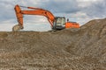 A large yellow excavator moving stone in a quarry Royalty Free Stock Photo