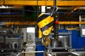 Bridge lifting Crane Hook against the background of the Assembly Line industrial factory. Royalty Free Stock Photo