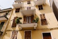 Large yellow Italian house with colourful Windows and vases. Stylish home