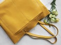 Large yellow leather bag and flowers