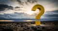 A yellow question mark stands on a rocky landscape under a dramatic cloudy sky at sunset time Royalty Free Stock Photo