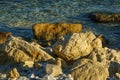 Large yellow rocks against the backdrop of the blue sea at sunset. Sea stones and rocks of different sizes and texture on beach Royalty Free Stock Photo