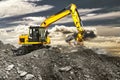 A large yellow wheeled excavator is working in a quarry. Heavy construction hydraulic equipment. excavation. Rental of