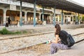 A woman sitting on the platform of the Larissa Train Station.