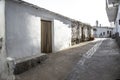 Laroles street with whitewashed walls with a door and bench attached to the facade and a typical Alpujarra fireplace