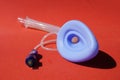 Laryngeal mask airway for emergency medical help on a red backgroun.