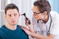 Laryngologist examining patient ears