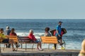 Las Americas,Tenerife, Spain - January 21, 2020: People on the waterfront, walking on promenade and relax sitting on benches near