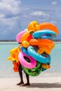Dramatic image of a man selling inflatable tubes for tourist on the caribbean coast. Royalty Free Stock Photo