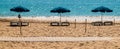 Three blue beach umbrellas on las Teresitas Beach, Tenerife, Spain.