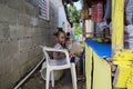 LAS TERRENAS, DOMINICAN REPUBLIC - SEPTEMBER 26, 2016: unidentified little girl sitting with a doll in chair and selling some frui Royalty Free Stock Photo