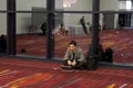 Young asian businessman sitting on the floor works on his laptop at the end of the day at CES Royalty Free Stock Photo