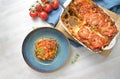 Lasagna, casserole dish of flat pasta sheets, ground beef, vegetables and tomatoes topped with melted cheese in a casserole and on Royalty Free Stock Photo