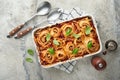 Lasagna. Homemade lasagna pasta rotolo bake with tomato sauce, cream cheese and basil on white skillet on light slate, stone or