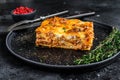 Lasagna with mince beef meat and tomato bolognese sauce on a plate. Black background. Top view Royalty Free Stock Photo